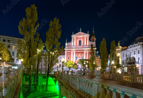 Preseren Square with Tromostovje bridge on Ljubljanica river at night with city lights in Slovenia Ljubjana with Cerkev Marijinega oznanjenja church photo