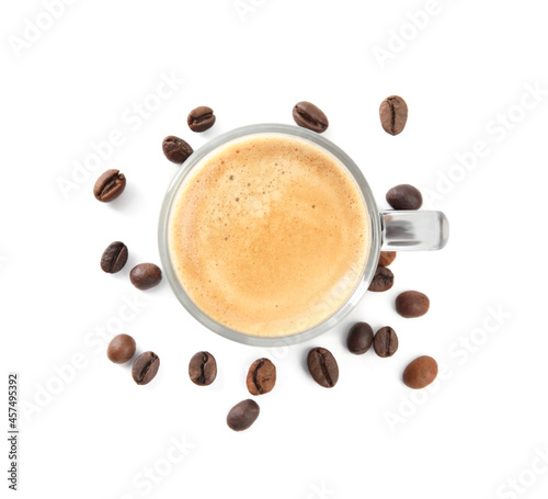 Cup of tasty coffee and beans isolated on white, top view