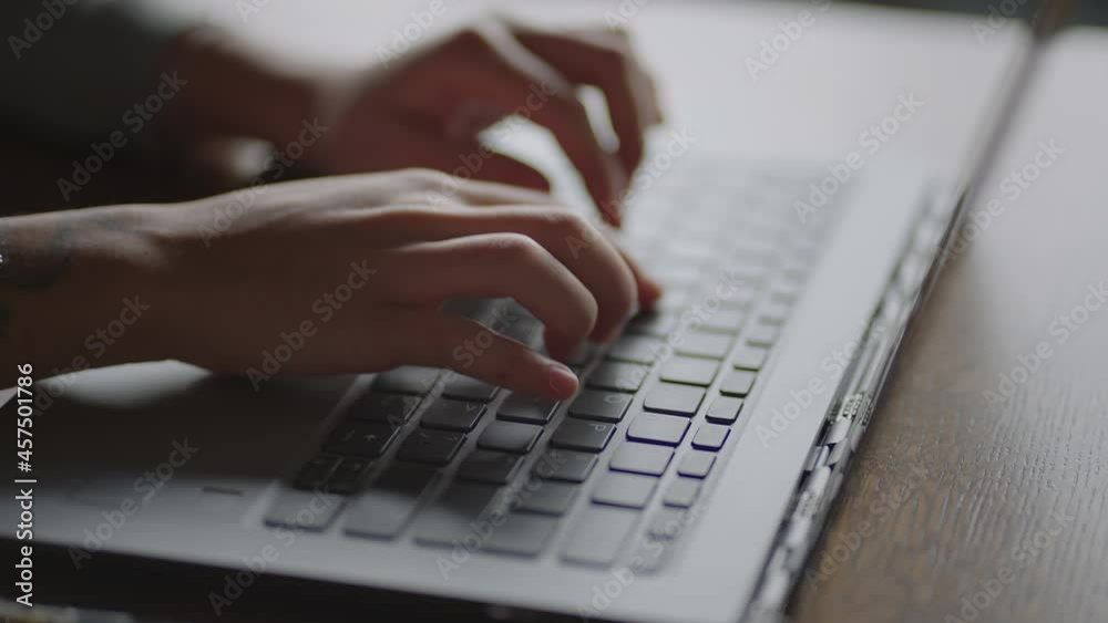 Close-up young woman typing on the keyboard of a laptop sitting at home. Remote work from home. Home Office Close-up young woman typing on the keyboard of a laptop sitting at home. Remote work from home. Home Office