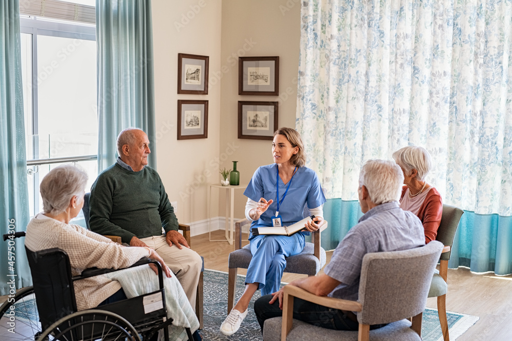 Nurse talking to senior people during group therapy Nurse talking to senior people during group therapy
