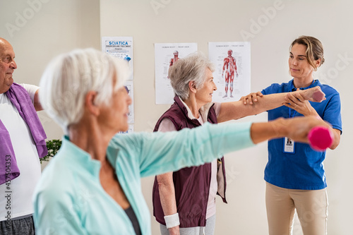Physiotherapist helping senior people exercise
