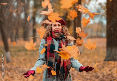 Dreamy beautiful girl with natural cutly hair on autumn background with colorful leaves. photo