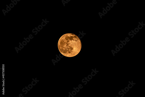 The yellow moon is in the dark sky