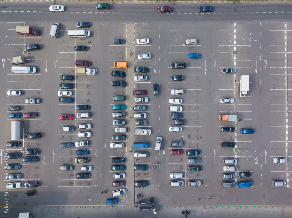 Drone view of a large car parking lot on a sunny summer day, horizontal car parking