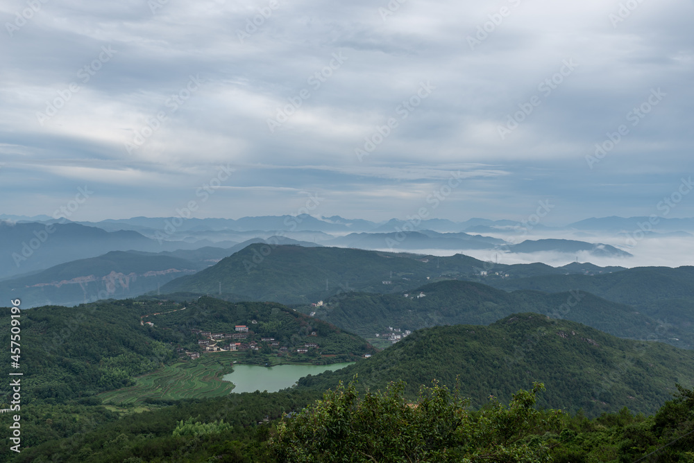 Early in the morning, peaks in the fog, fields and villages.