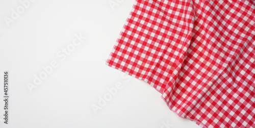 folded cotton red white checkered napkin on a white background