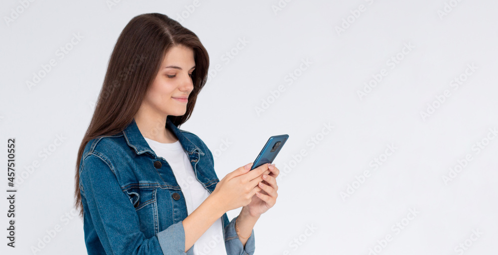 Pleased brunette woman writing message on smartphone over white background Pleased brunette woman writing message on smartphone over white background