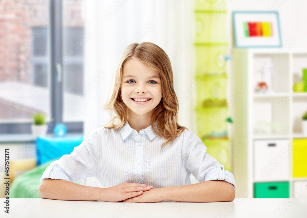 education, school and people concept - happy smiling student girl sitting at table over home room background education, school and people concept - happy smiling student girl sitting at table over home room background