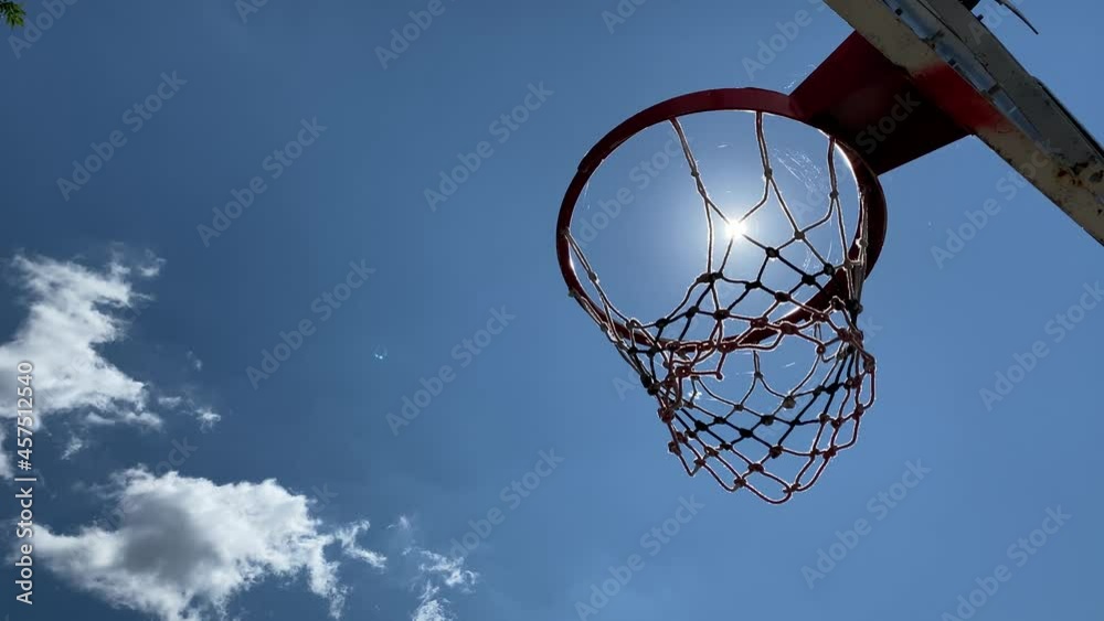 Close-up of basketball hoop on background of sun and blue sky. Close-up of basketball hoop on background of sun and blue sky.