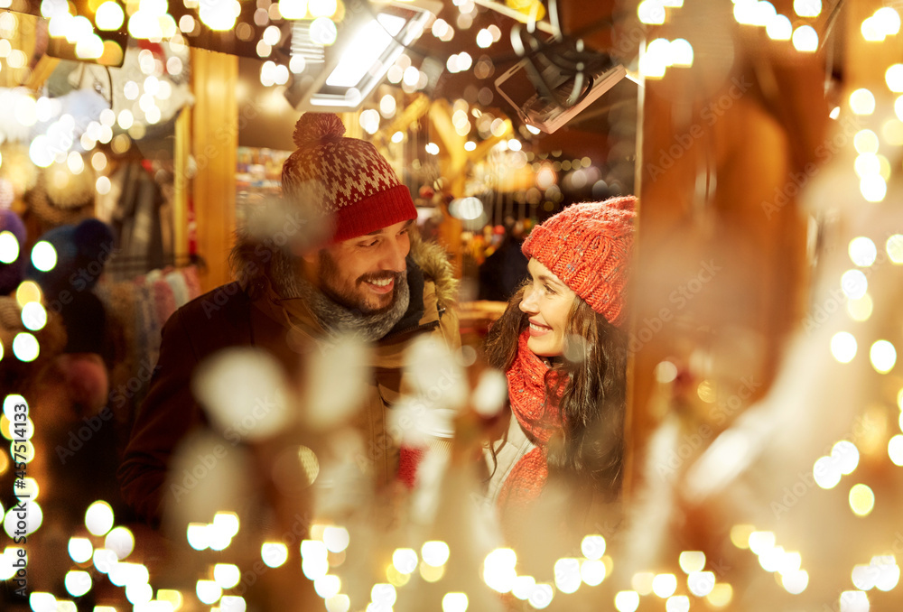 © Syda Productions - winter holidays and people concept - happy young at christmas market in evening over lights