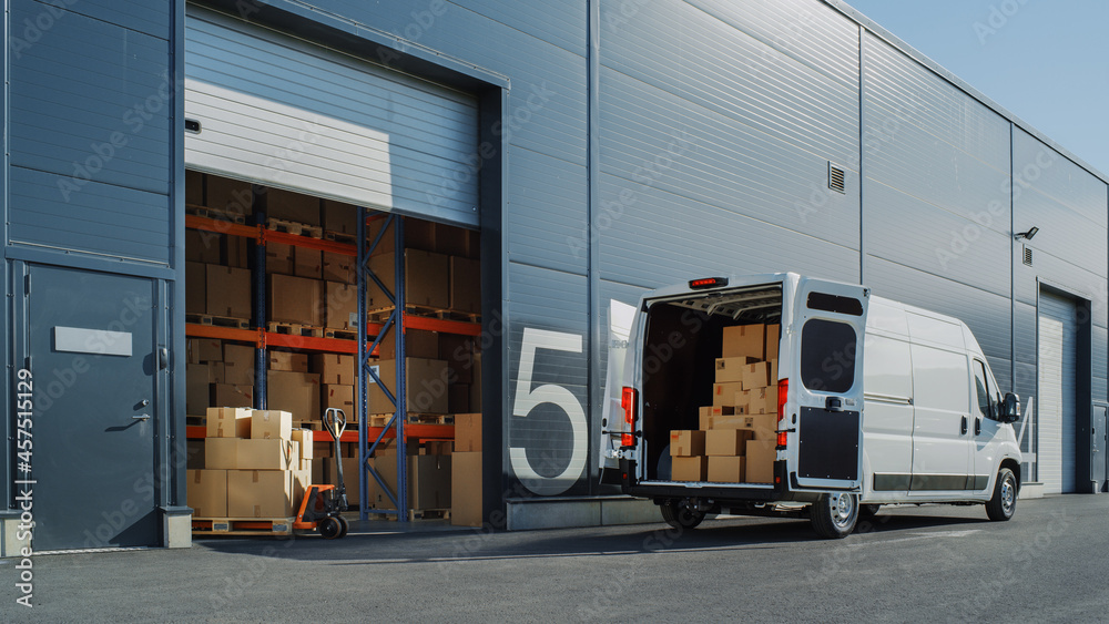Outside of Logistics Warehouse with Open Door, Delivery Van Loaded with Cardboard Boxes. Truck Delivering Online Orders, Purchases, E-Commerce Goods, Wholesale Merchandise. - obrazy, fototapety, plakaty 