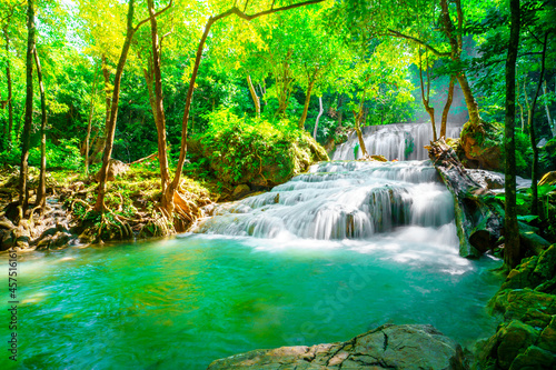 Waterfalls and fish swim in the emerald blue water in Erawan National Park. Erawan Waterfall is a beautiful natural rock waterfall in Kanchanaburi  Thailand.Onsen atmosphere. soft focus.