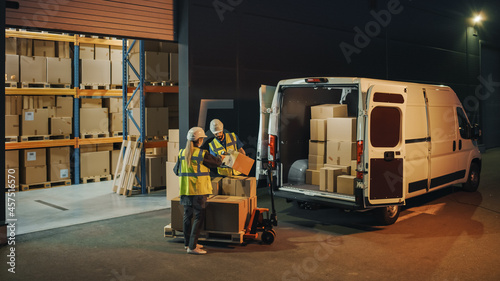 Outside of Logistics Retail Warehouse: Manager Using Tablet Computer and Scanner, talking to Worker Loading Delivery Truck with Cardboard Boxes, Online Orders, Medicine Supply, E-Commerce. Evening