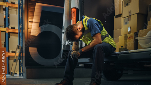 Latin Male Worker Wearing Hard Hat Loads Cardboard Boxes into Delivery Truck, Rests. Online Orders, E-Commerce Goods, Food, Medicine. Tired Overworked Frontline Hero. Dramatic Shot