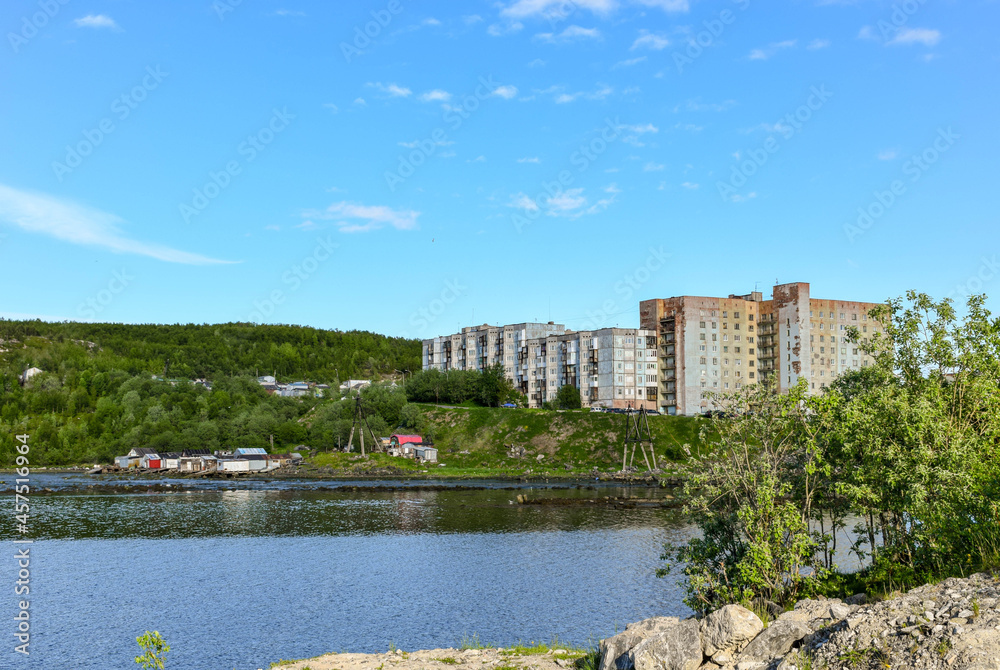 Multi-storey residential buildings on the shore of the bay on a sunny summer day in the north of Russia. 