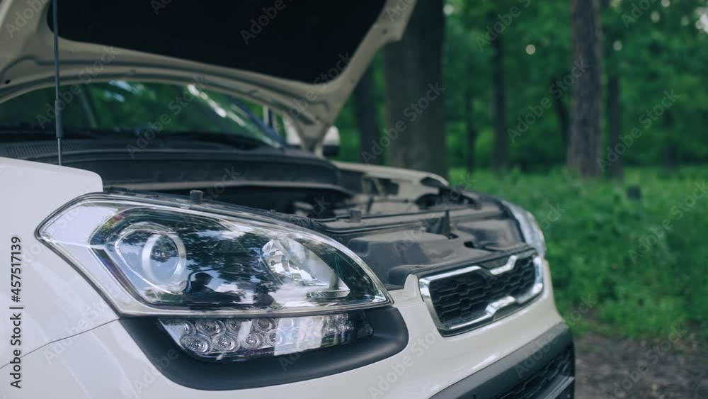 Broken automobile with open hood on the roadside, vehicle service, maintenance Broken automobile with open hood on the roadside, vehicle service, maintenance