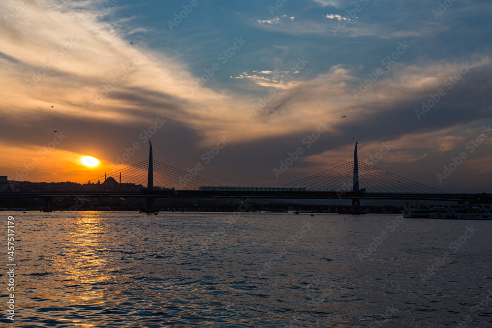 トルコ　イスタンブールの金角湾にかかるアタチュルク橋と夕焼けでオレンジに染まった空