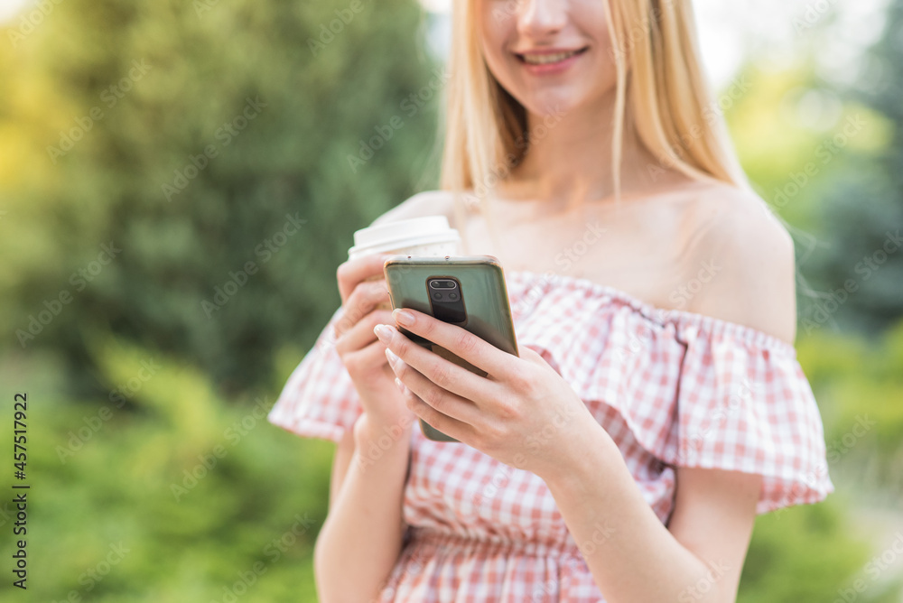 Happy and attractive blonde girl holding a smartphone. Online working. Freelance Happy and attractive blonde girl holding a smartphone. Online working. Freelance