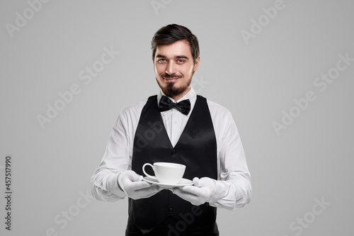 Elegant waiter with cup of coffee