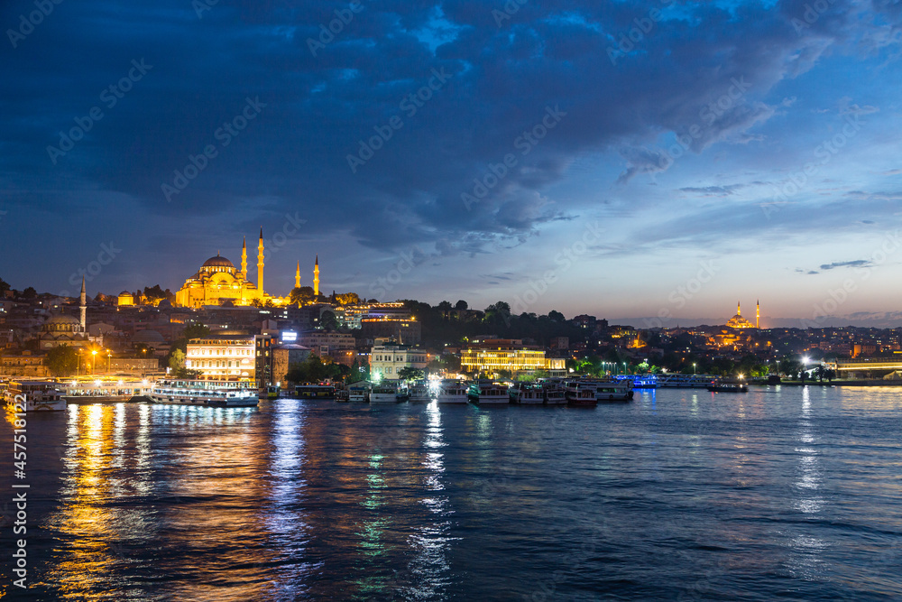 トルコ　夜のイスタンブールの金角湾と旧市街の街並みと丘の上に建つライトアップされたスレイマニエ・モスク