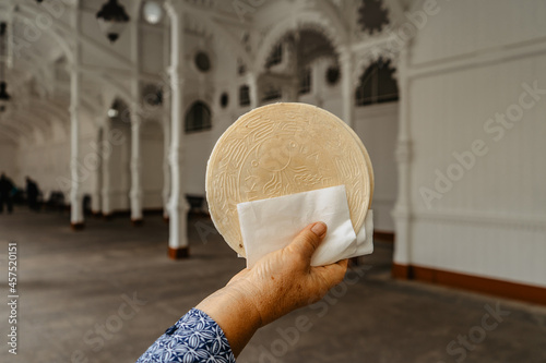 Famous Carlsbad wafer,CZ: lazenske oplatky, originated in 1867. Senior woman hand holding traditional Czech sweet cookie snack made in Karlovy Vary,famous spa city in UNESCO.Tasty food background