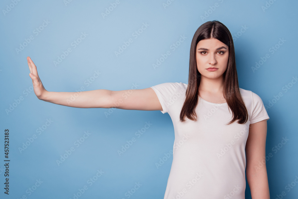 Portrait of serious focused strict lady raise palm show ban gesture on blue background Portrait of serious focused strict lady raise palm show ban gesture on blue background