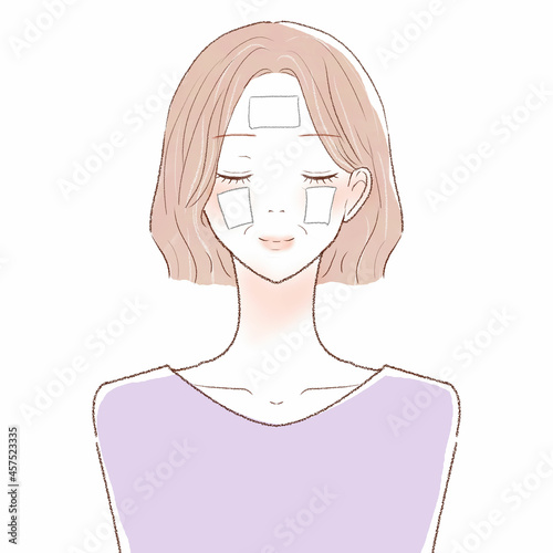 コットンパックで顔を保湿する中年女性