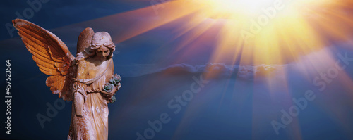 Fotografiet Antique statue of beautiful  angel in the sunlight against mountains in fog