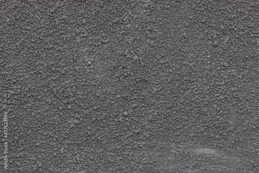 Concrete putty texture. Plaster on the wall. Rough granular surface. The surface is gray.