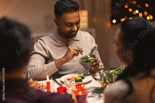 holidays  party and celebration concept - happy man with friends having christmas dinner at home