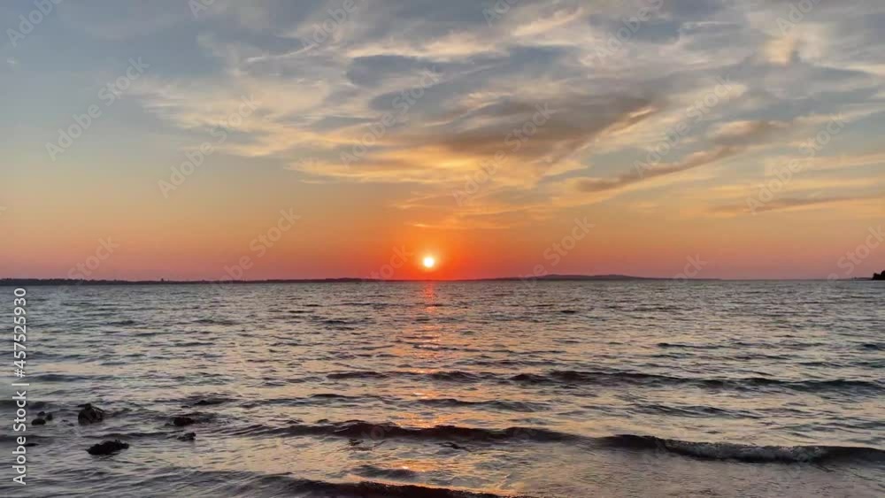 Calming waves with sunset sun over horizon