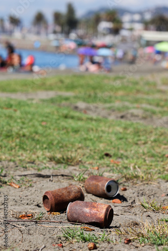 Travelers or tourists dropped cans, very rusty like polluted trash on the beach long ago. Tin can damage and rust.