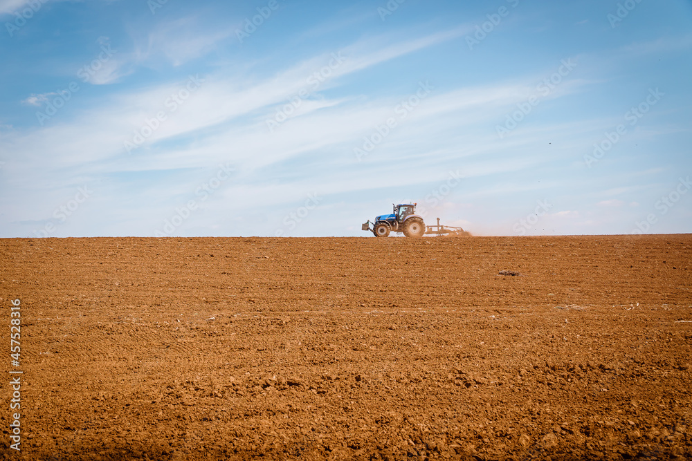 Naklejka premium tractor ploughing field