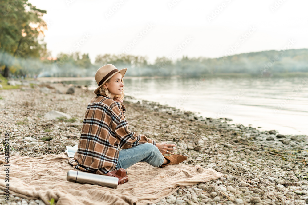 Women wearing in autumn outfit relaxing on the beach