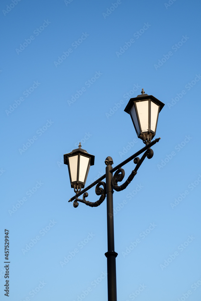 Daytime vintage street lamp post lantern lanterns in park with sky and clouds
