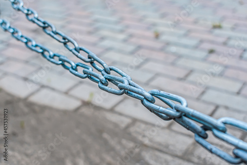 Long tensioned metal chain over the road with double winding