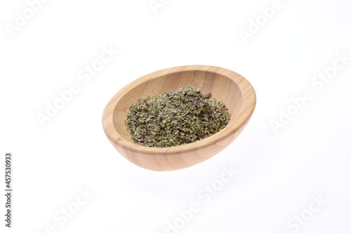 Marjoram. A spice in a wooden bowl on a white background. Food.