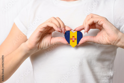 Flag of Madeira in the shape of a heart in the hands of a girl. Love Madeira.