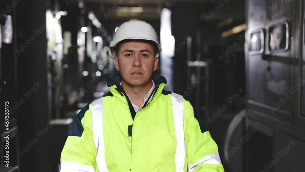 Portrait of employee serious asian man engineer worker wearing safety uniform, goggles and hardhat looking at camera on site factory warehouse background Portrait of employee serious asian man engineer worker wearing safety uniform, goggles and hardhat looking at camera on site factory warehouse background