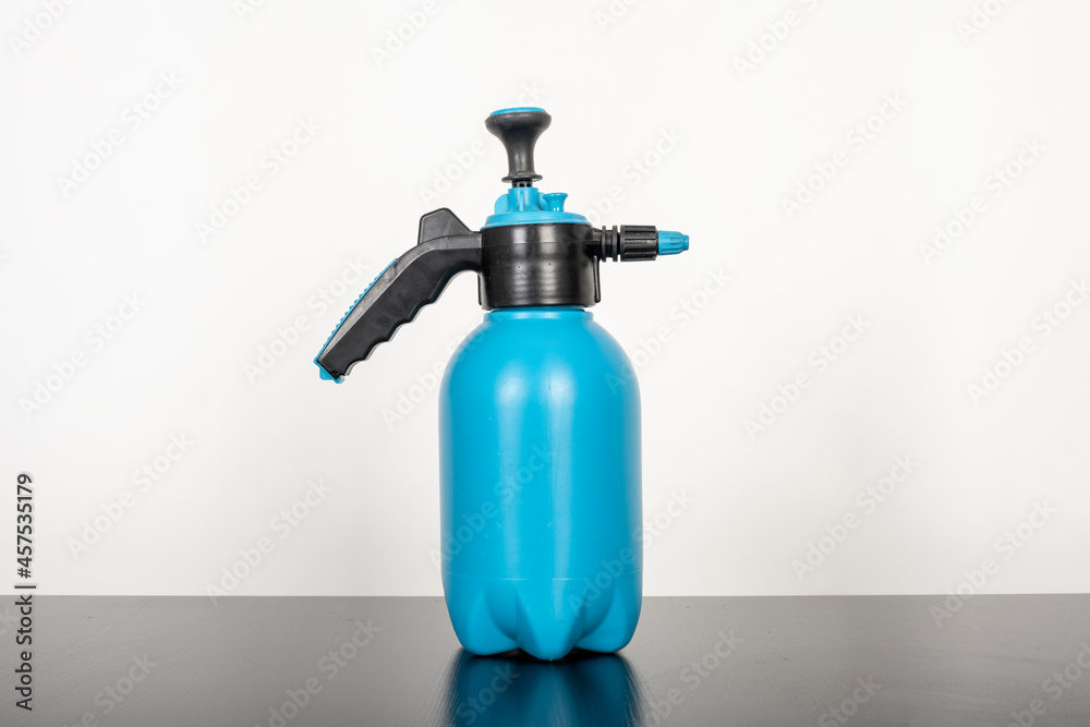 The garden watering can is set on a black table against a white background The garden watering can is set on a black table against a white background