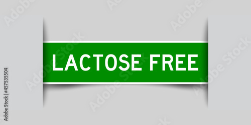 Inserted green color label sticker with word lactose free on gray background