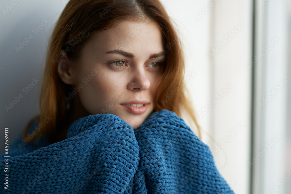 pretty woman sitting near the window with a blue plaid Lifestyle pretty woman sitting near the window with a blue plaid Lifestyle