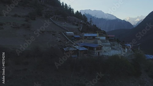 Mysterious twilight panoramic flight near lost mountain village, reveals dark snowy Paungda Danga ridge, Nepal photo