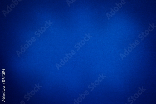 Abstract blue paper textured background with vignette and copy space. Paper texture.
