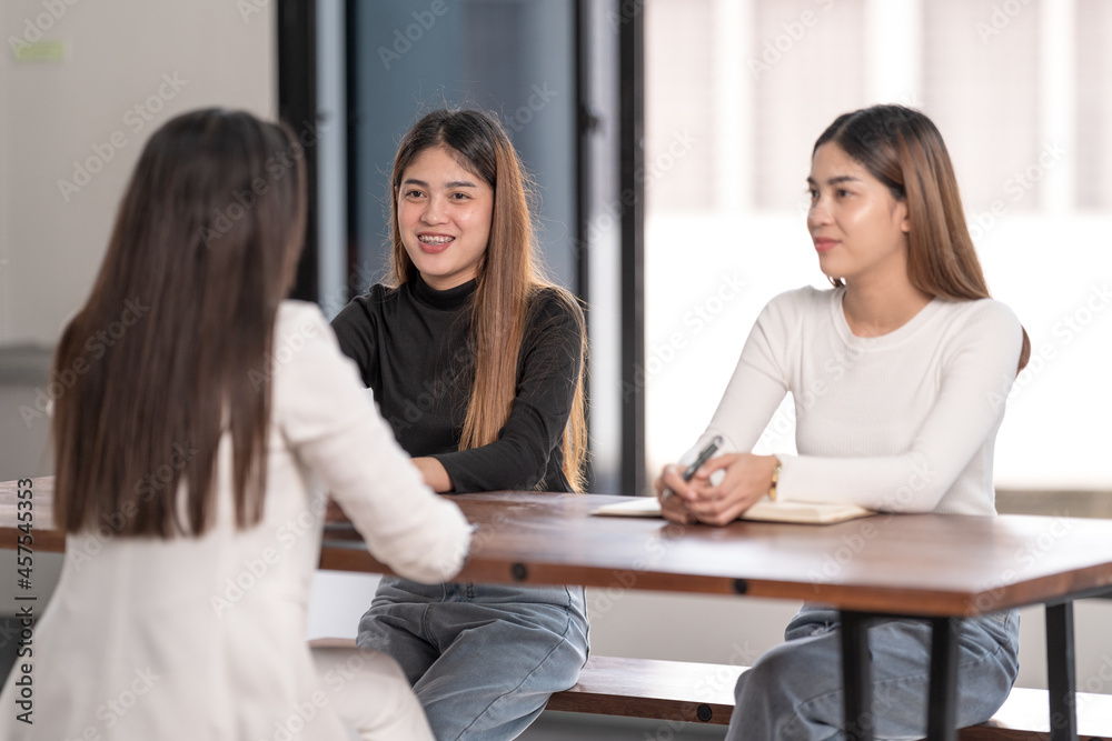 Young Asian college students have meetings with a teacher advisor or a tutor to discuss the project Young Asian college students have meetings with a teacher advisor or a tutor to discuss the project