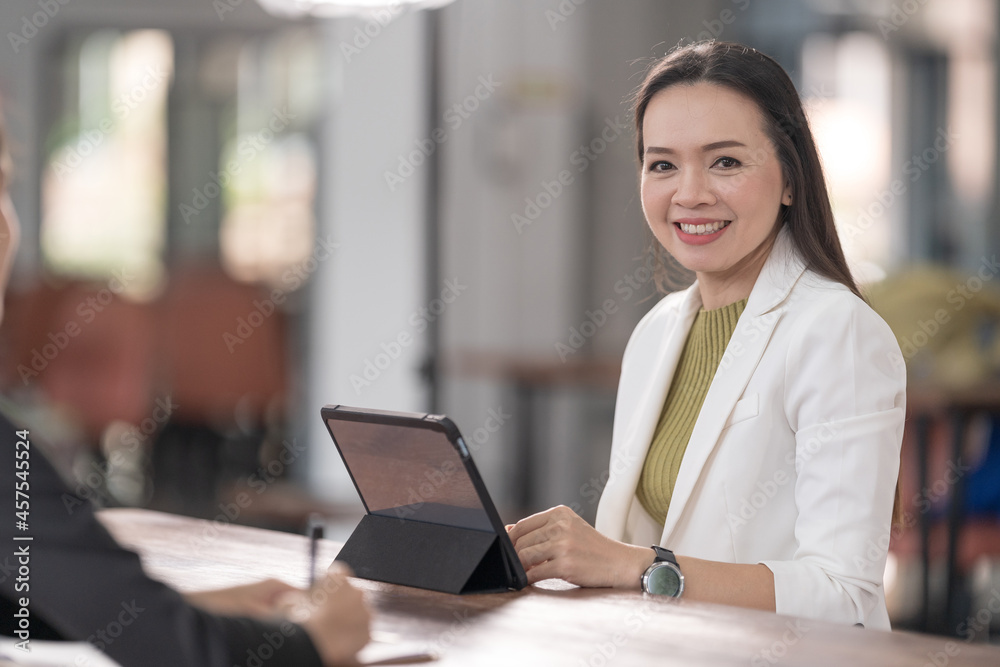 Young Asian college students have meetings with a teacher advisor or a tutor to discuss the project Young Asian college students have meetings with a teacher advisor or a tutor to discuss the project