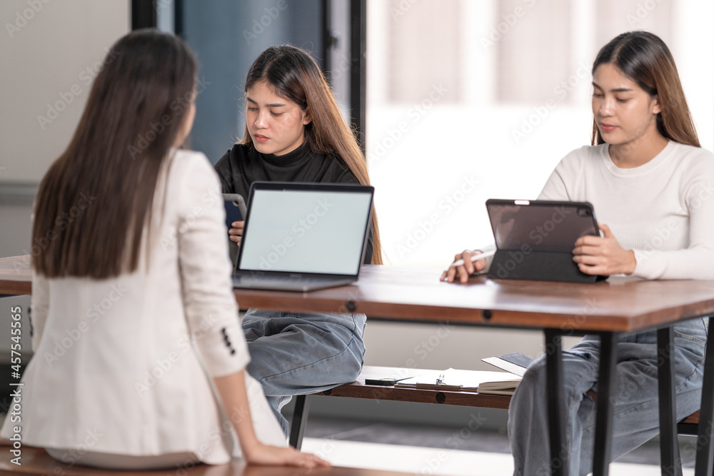 Young Asian college students have meetings with a teacher advisor or a tutor to discuss the project Young Asian college students have meetings with a teacher advisor or a tutor to discuss the project