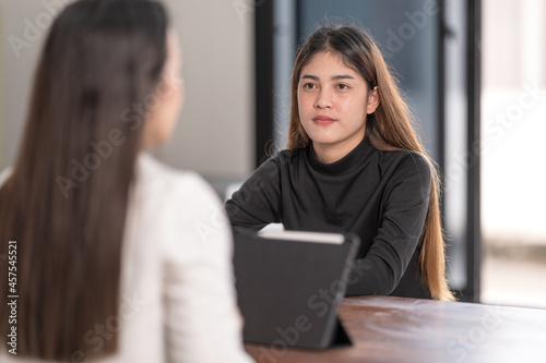 Young Asian college students have meetings with a teacher advisor or a tutor to discuss the project