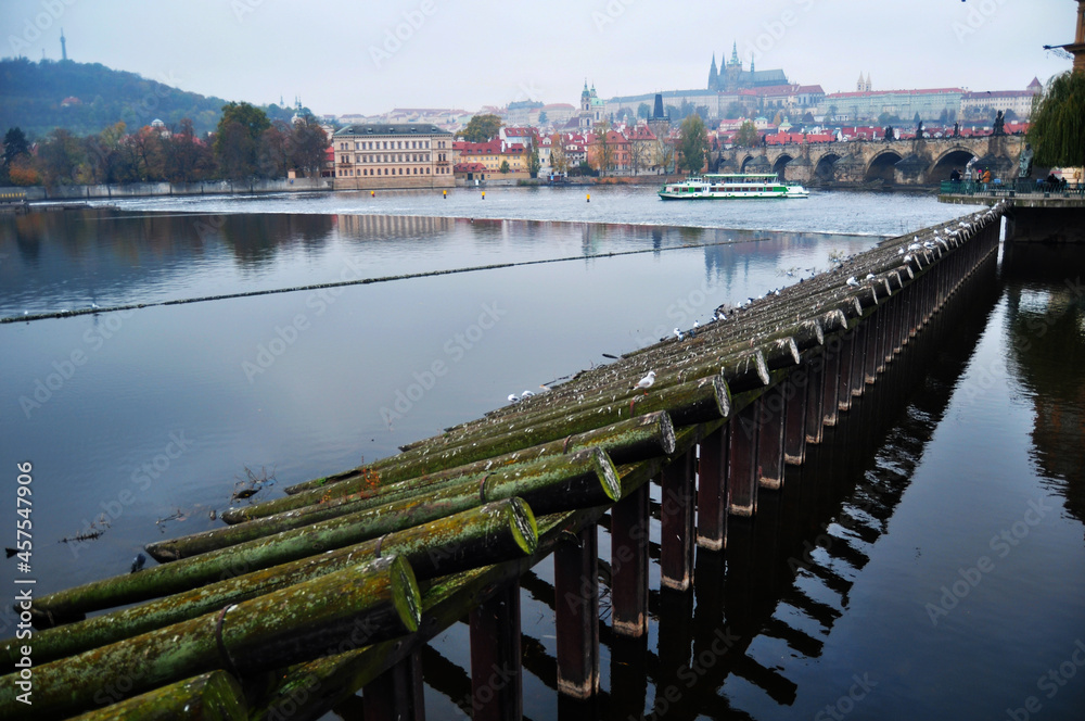 View landscape and trunk wooden barrage weir dam and wood barrier boat in Vltava river at Praha city in Prague, Czech Republic