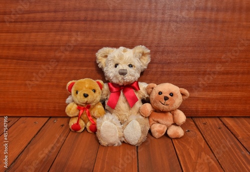 teddy bear with red ribbons.  Wooden background 